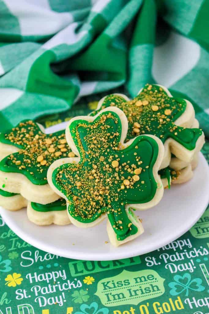Clover cookies for St. Patrick's Day on a white plate.
