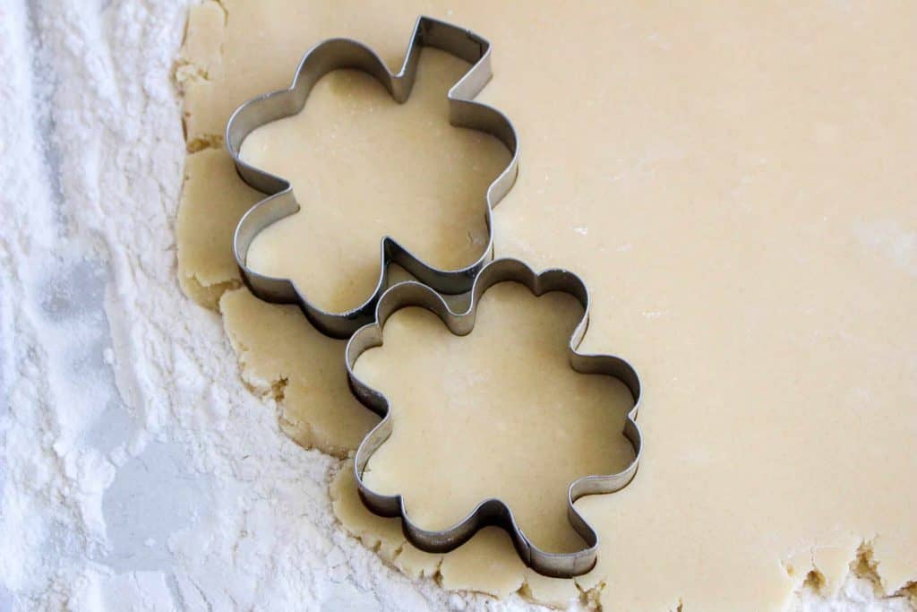 Clover cookie cutters cutting out dough.