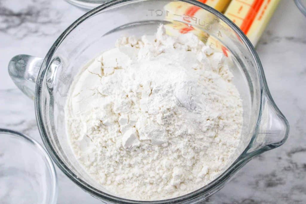 Dry ingredients for sugar cookie in a glass mixing bowl