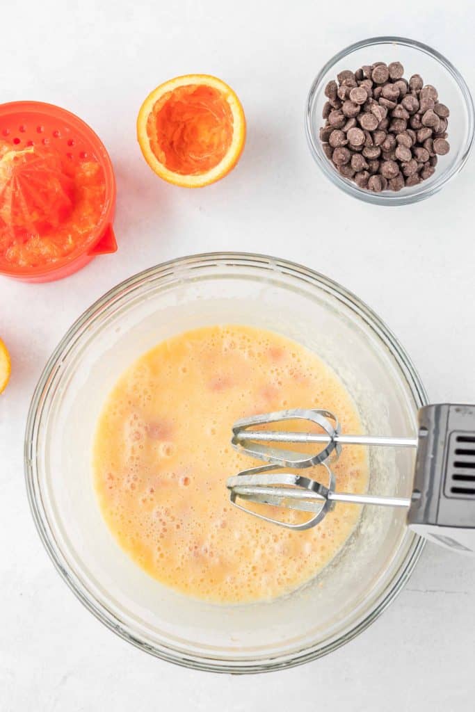 Orange muffin wet ingredients in. glass bowl.