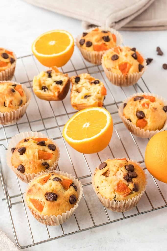 Orange muffins on a baking rack.