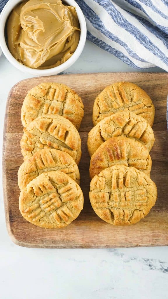 Eight peanut butter cookies on a cutting board.