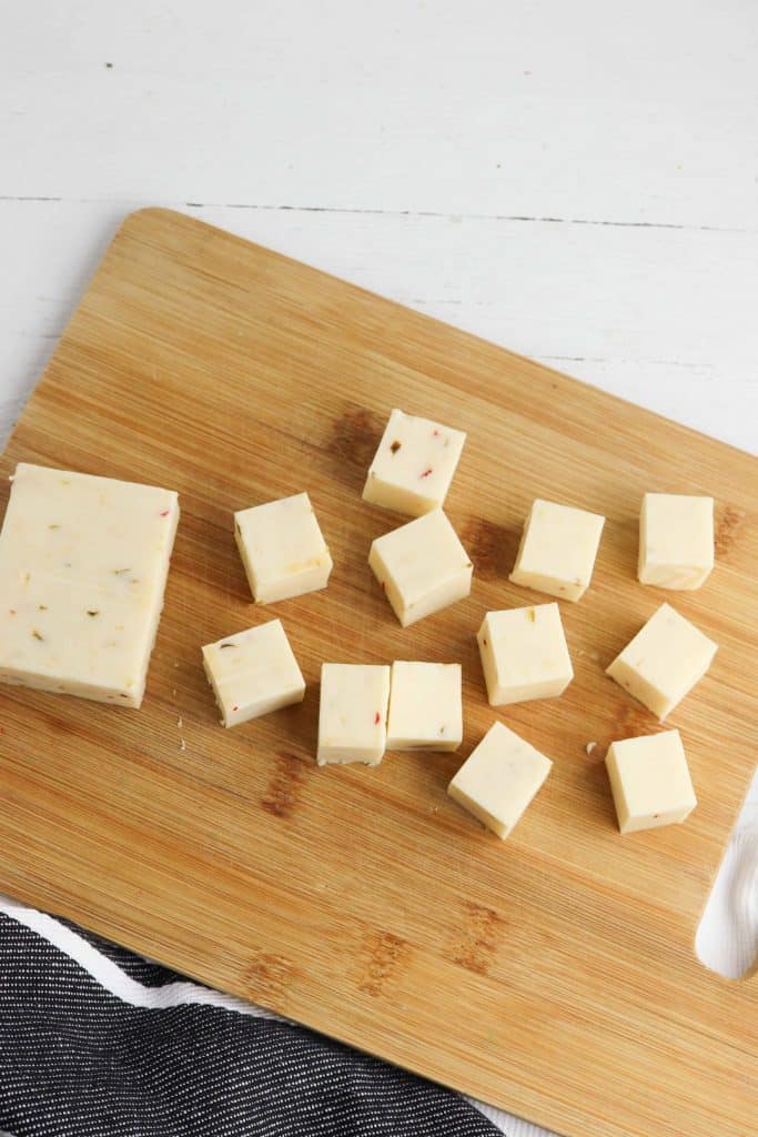 Pepper Jack cheese cubes on a cutting board.