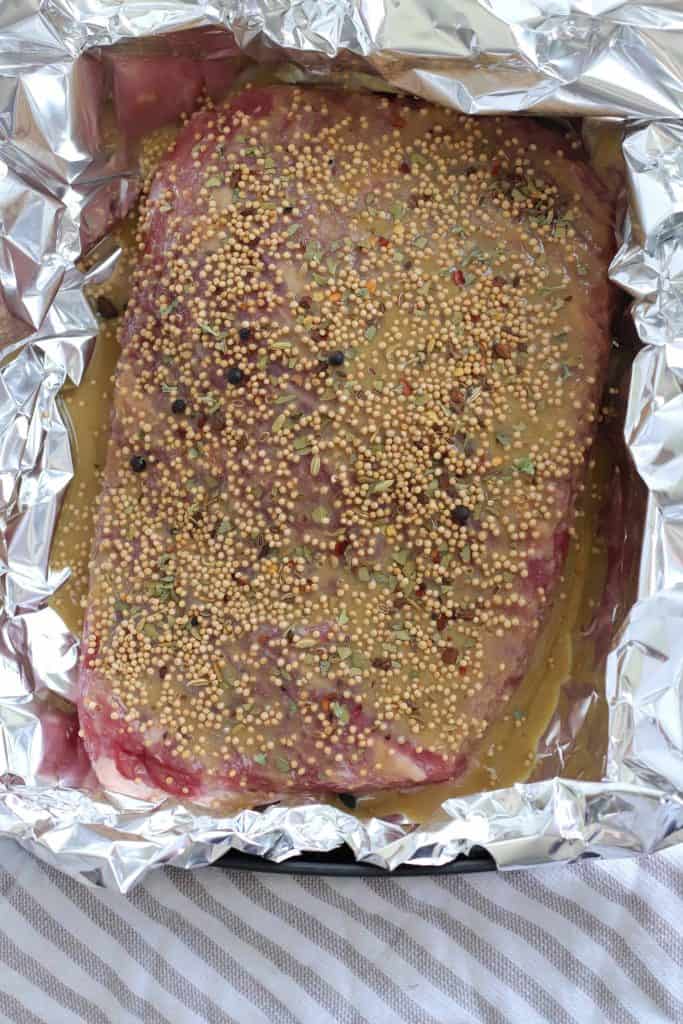 Seasoned corned beef in foil lined air fryer basket.