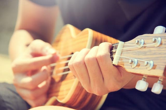 Closeup of man playing the ukulele.