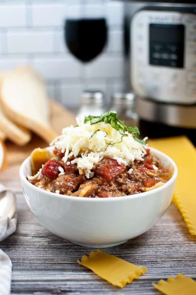 A bowl of lasagna soup in front of an Instant Pot.