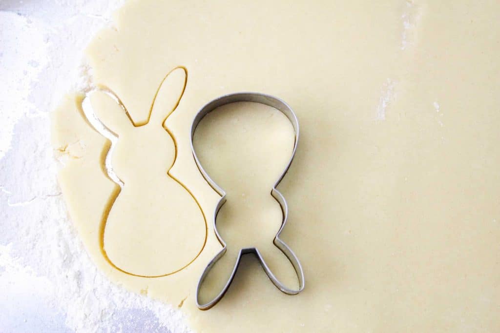 Cutting out bunny shaped cookies.