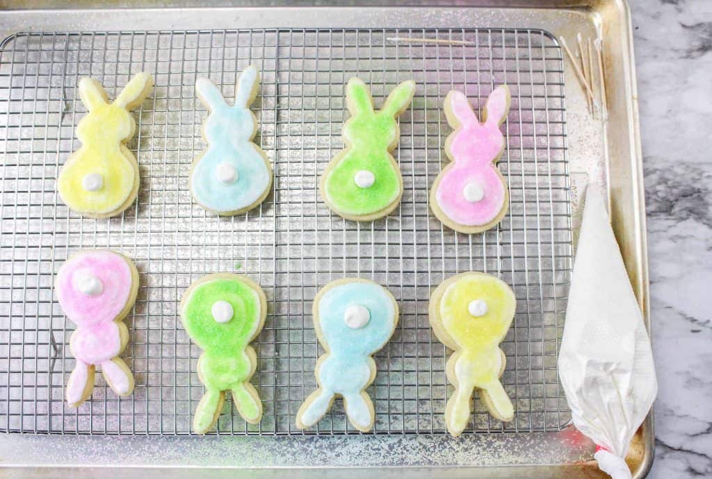 Easter bunny tail cookies on a wire baking rack.