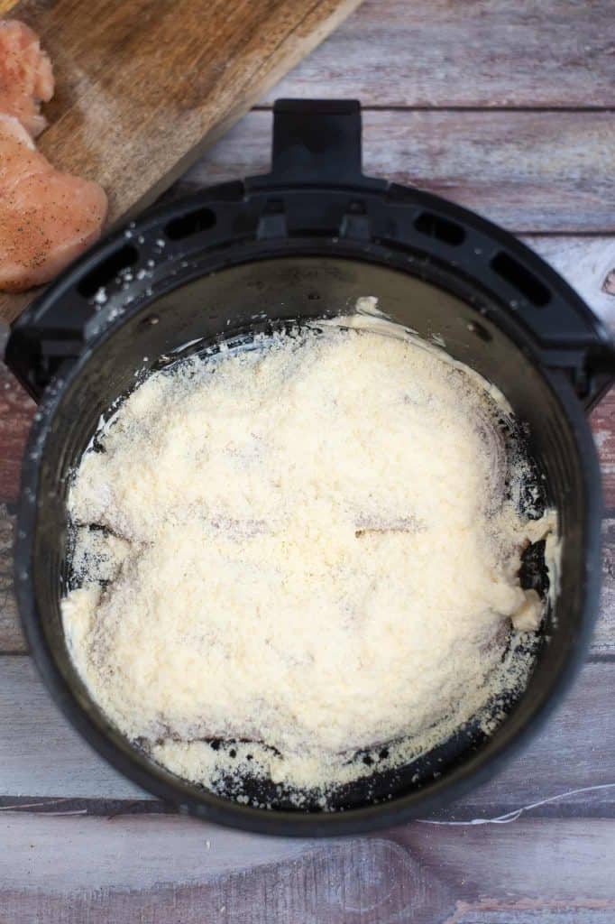 Grated Parmesan cheese over chicken breasts.