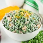 Green pea salad in a white bowl.