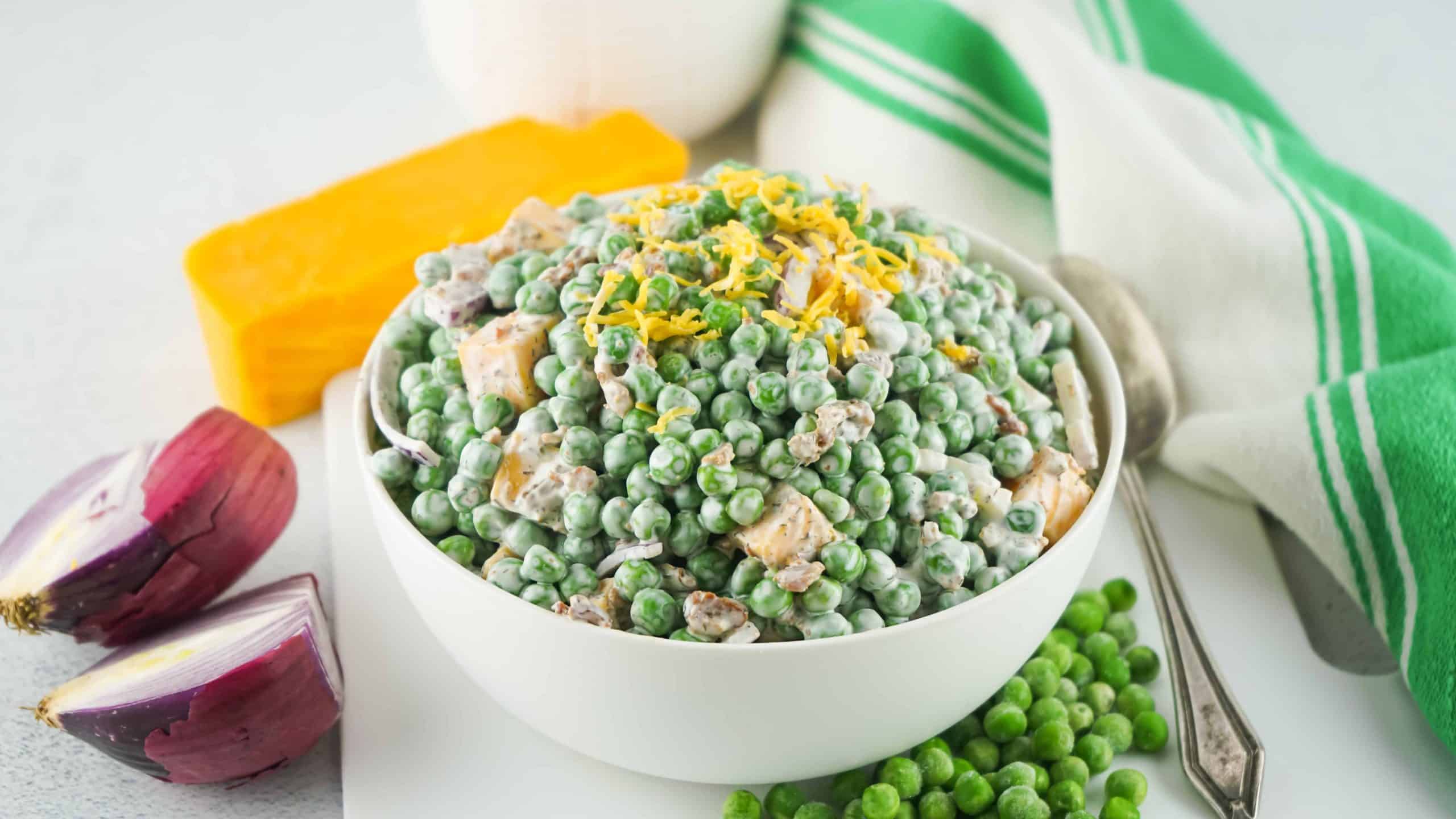 Green pea salad in a white bowl.
