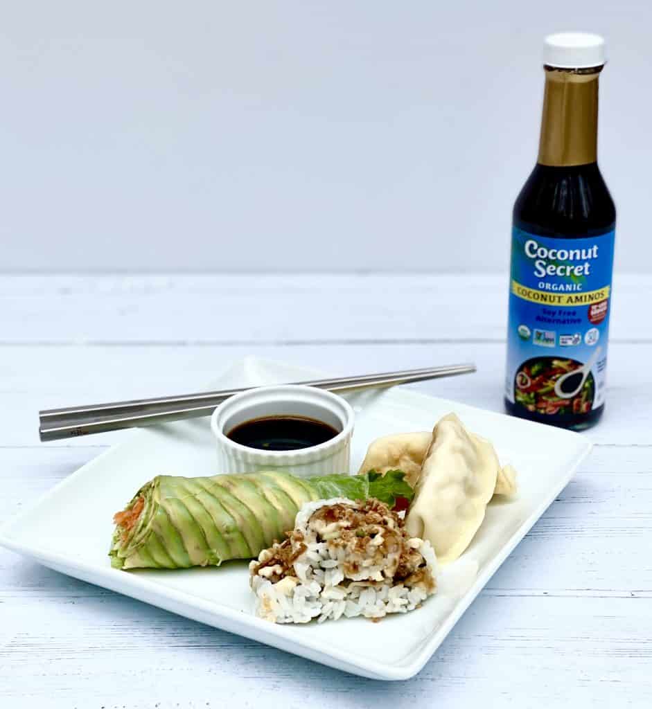 Asian food on a square plate with a bottle of Nutiva Coconut Secret Aminos