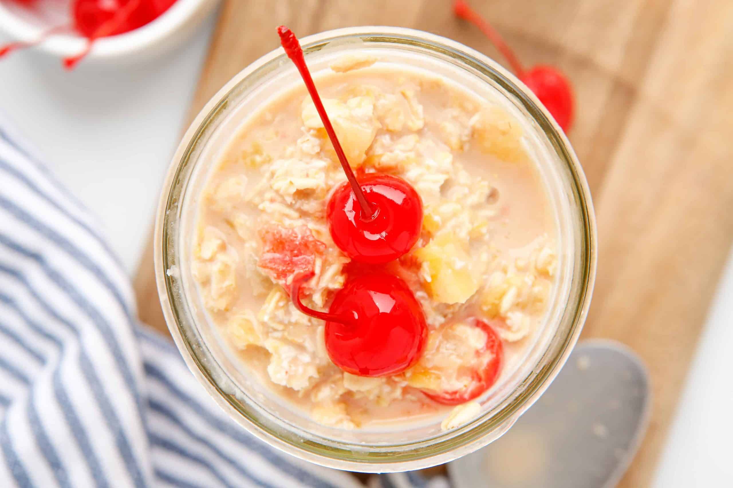 Overhead view of Pineapple Overnight Oats with cherries on top of it.
