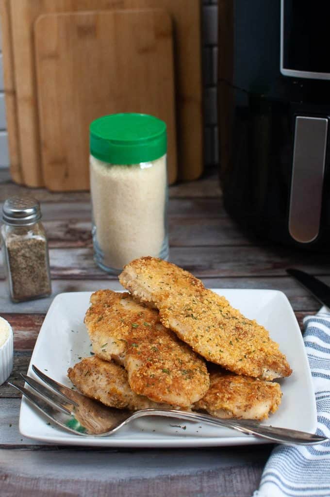 Parmesan crusted chicken with mayo on a white plate.
