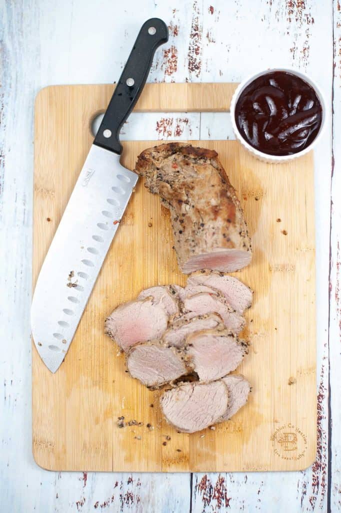 Sliced pork tenderloin on a cutting board.