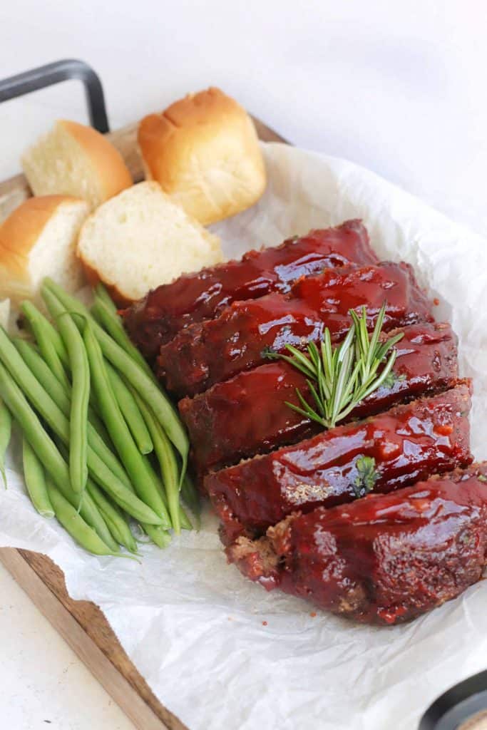 Air fryer Meatloaf on a platter with rolls.