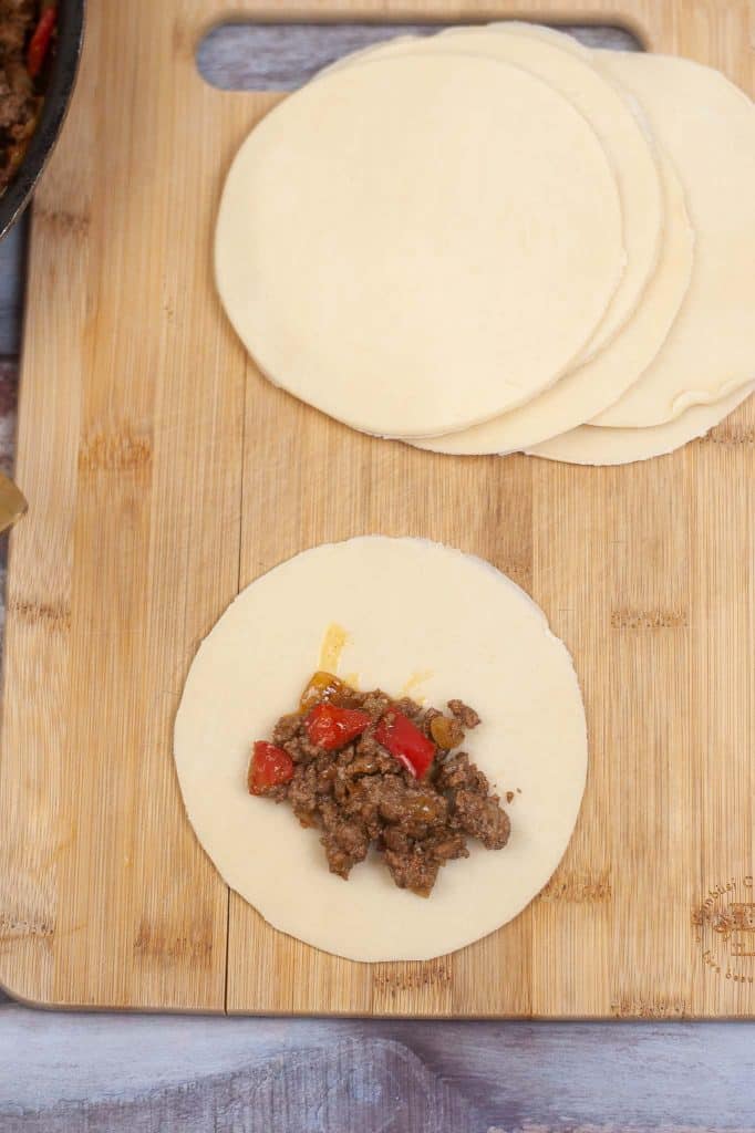 Filling empanadas with meat and vegetables.