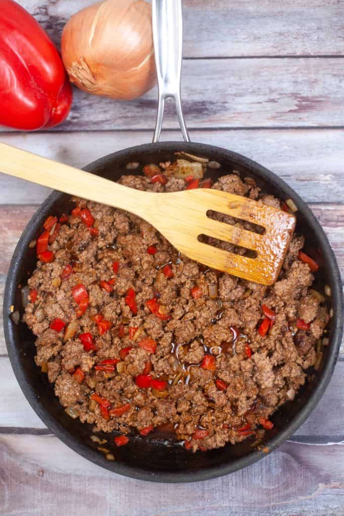 Ground beef in skillet with seasoning.