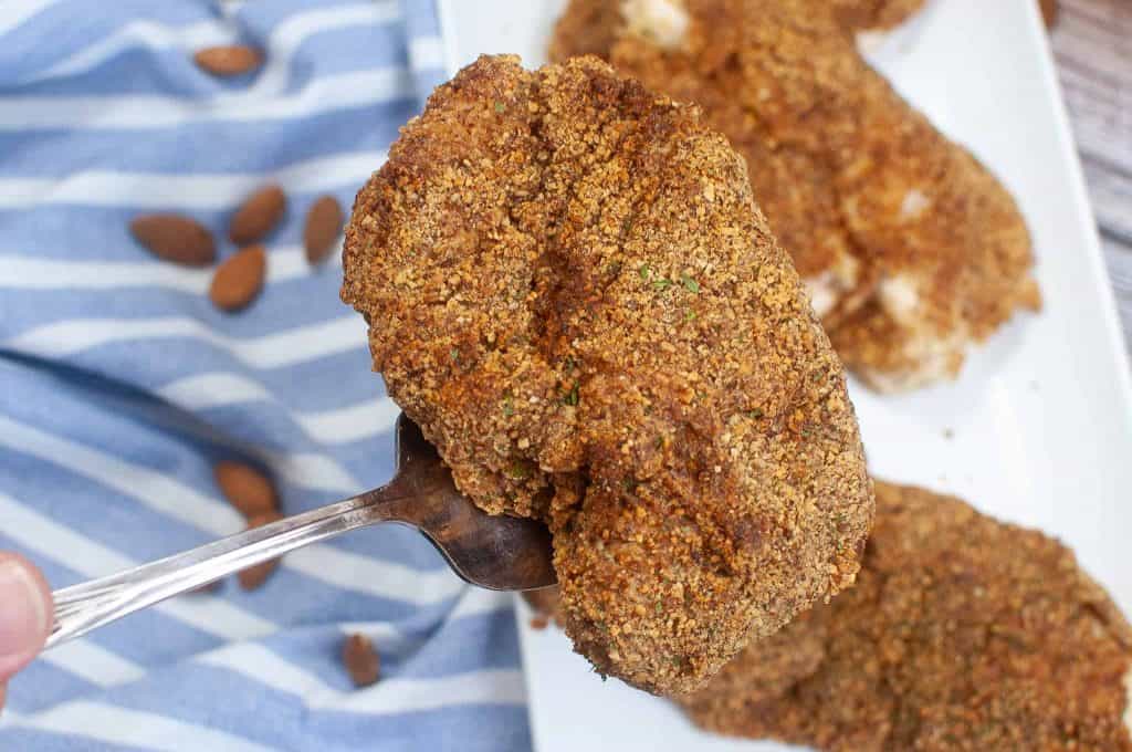 Closeup of almond chicken on a fork.