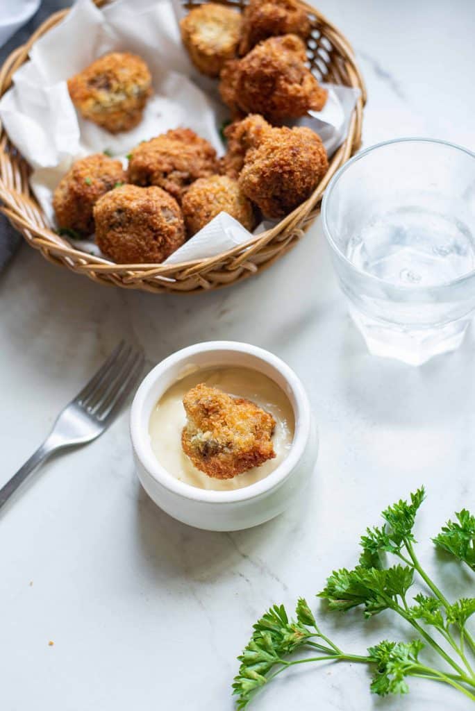 fried mushrooms in basket with dipping sauce.