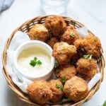 Fried mushrooms in a basket with sauce.
