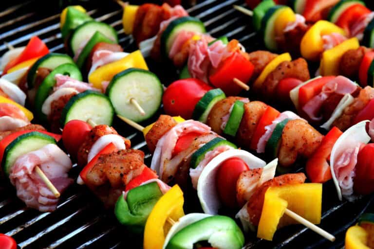 Meat and vegetable skewers on a grill.