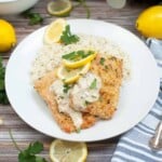 Parmesan crusted salmon with creamy wine sauce on a white plate.