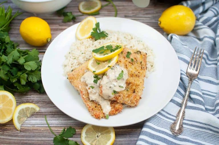 Parmesan crusted salmon with creamy wine sauce on a white plate.