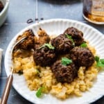 Sweet and spicy meatballs on a white plate with a fork.
