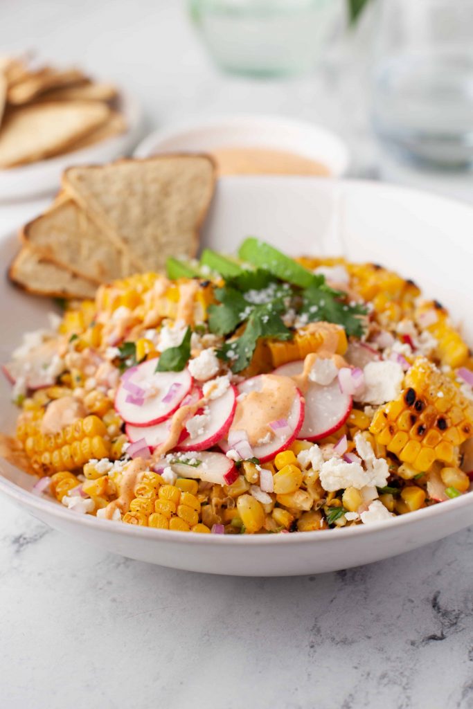 Mexican corn salad with slices of radish and cilantro on top.
