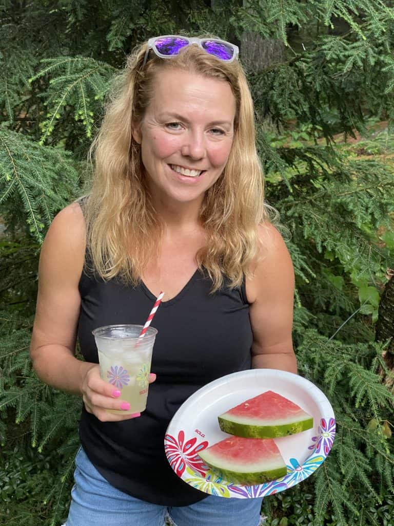 A woman holding Solo cups and plates.