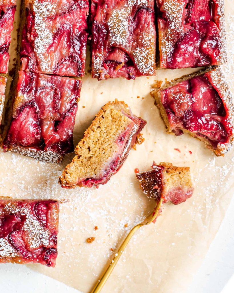 Strawberry bars with a fork on parchment paper.