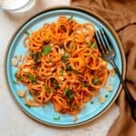 Overhead view of carrot noodles with peanut sauce.