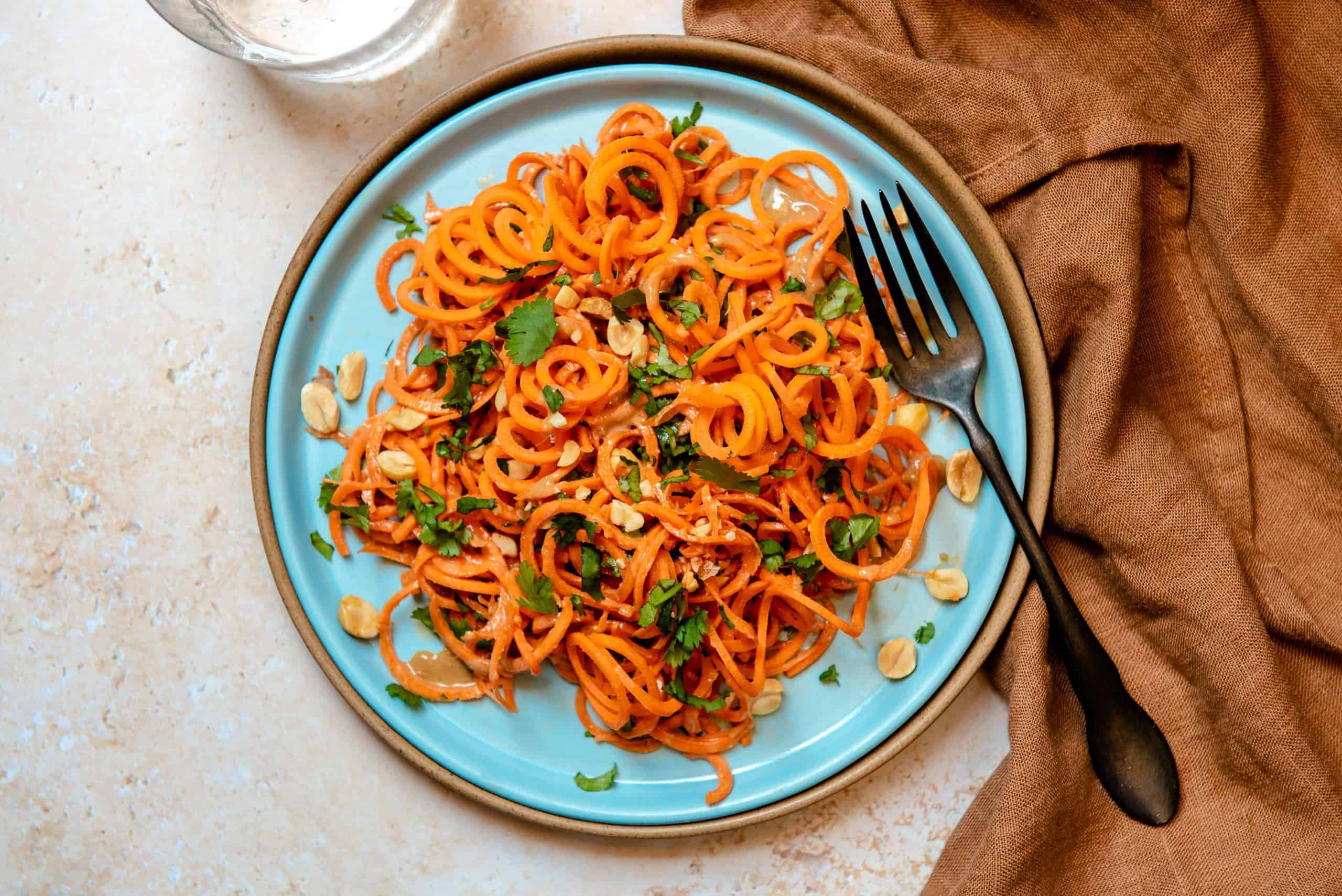Overhead view of carrot noodles with peanut sauce.