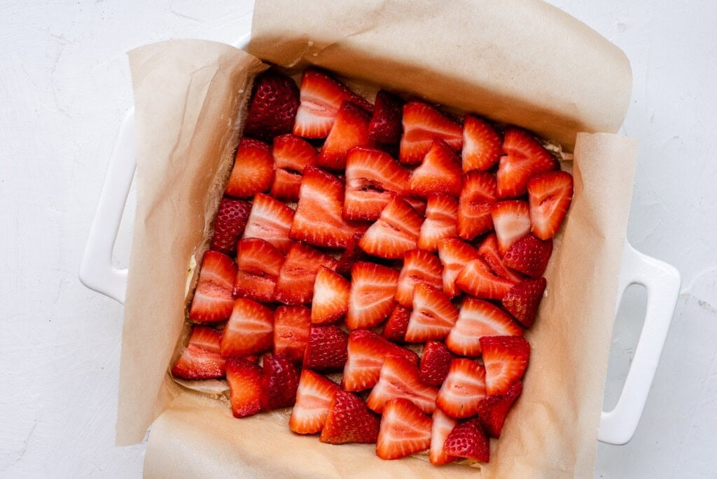 Sliced strawberries lining bottom of pan.