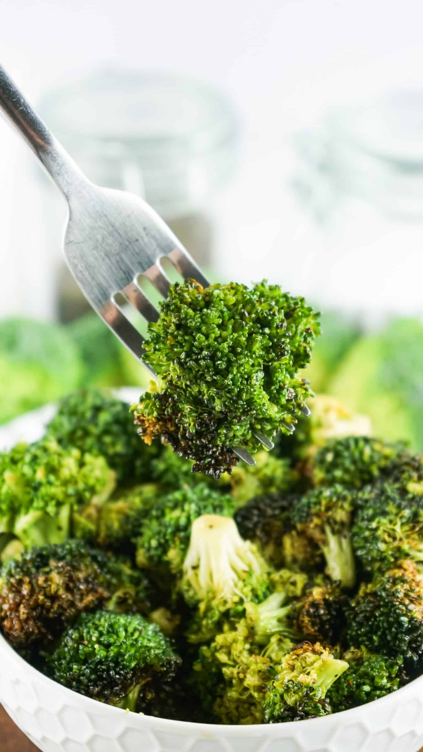 Piece of cooked broccoli on a fork.