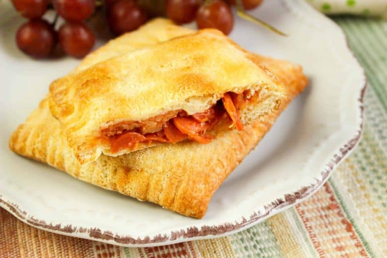 Closeup of pepperoni pizza pocket on a white plate.