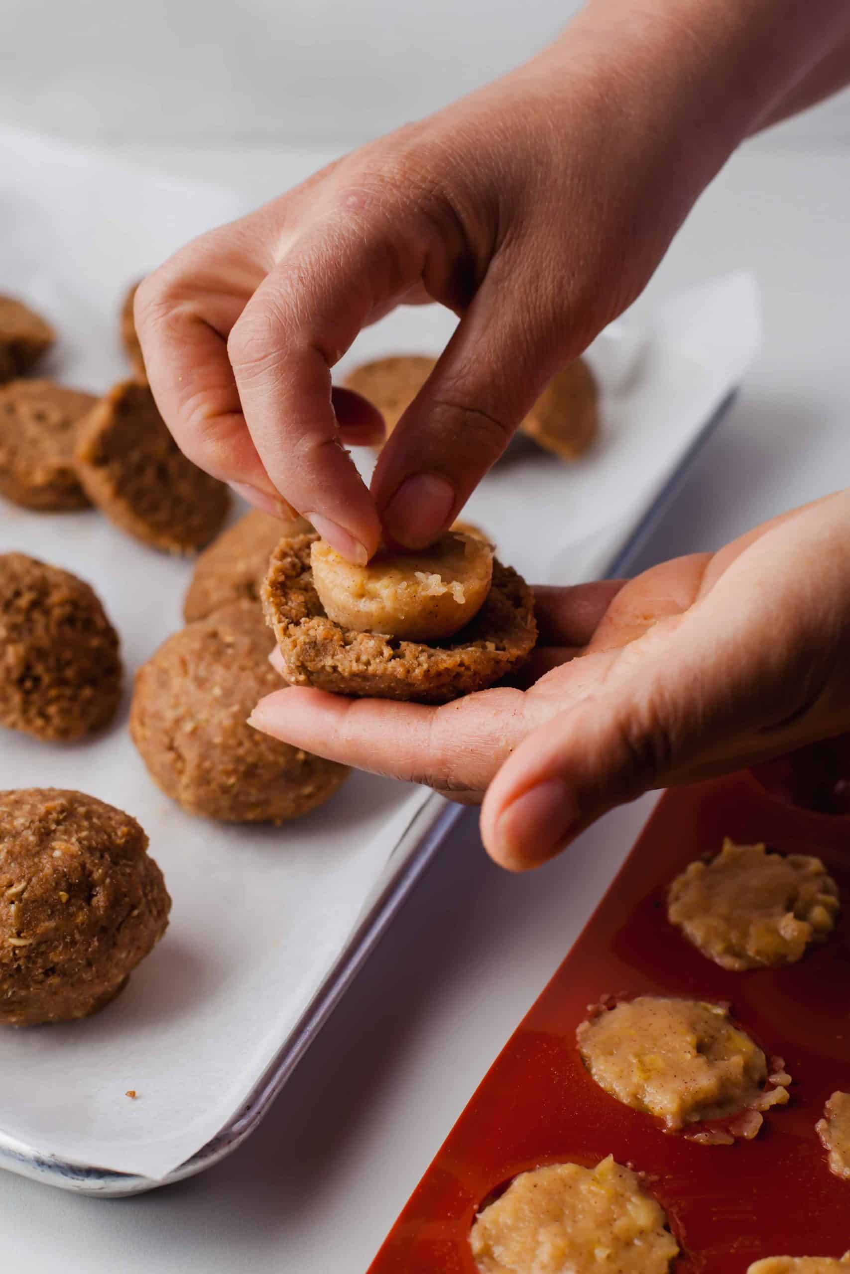 Inserting apple pie filling into cookie dough.