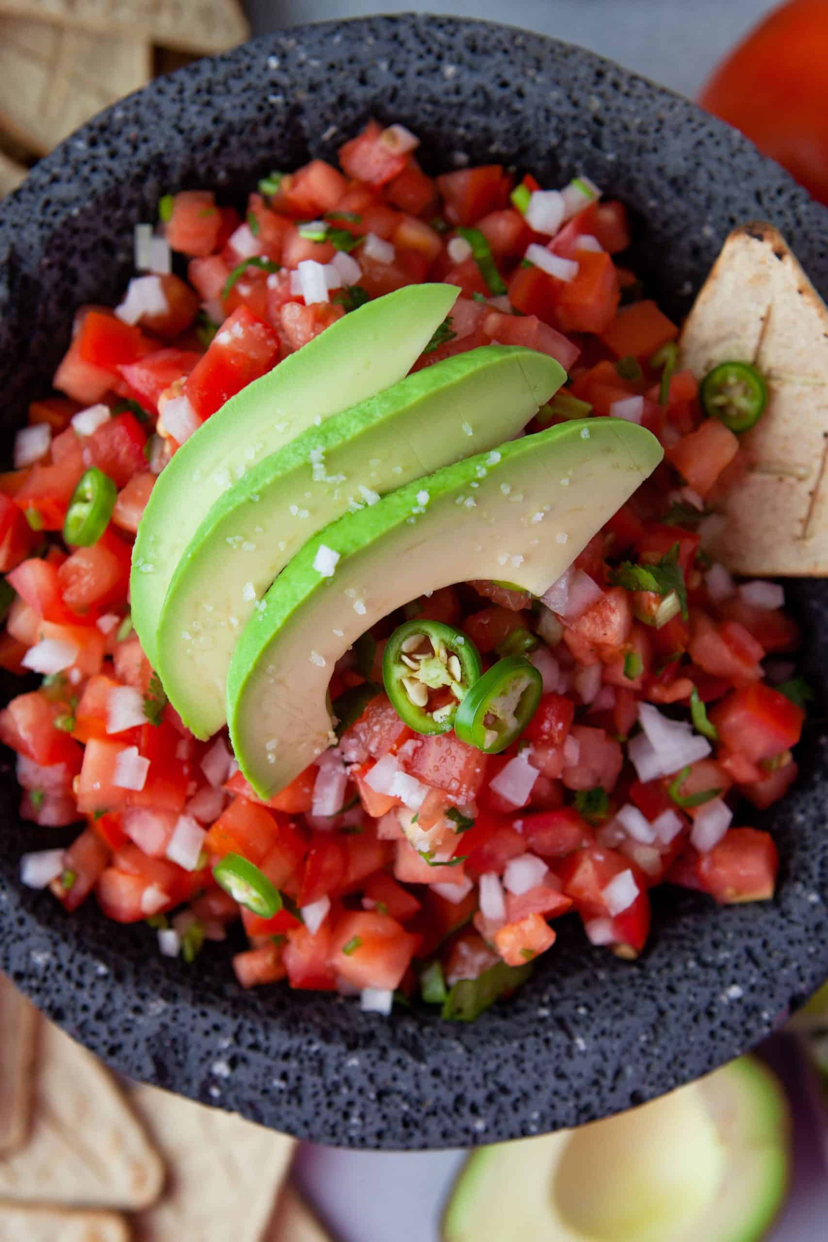 Overhead view of Pico de Gallo with avocado slices on top.