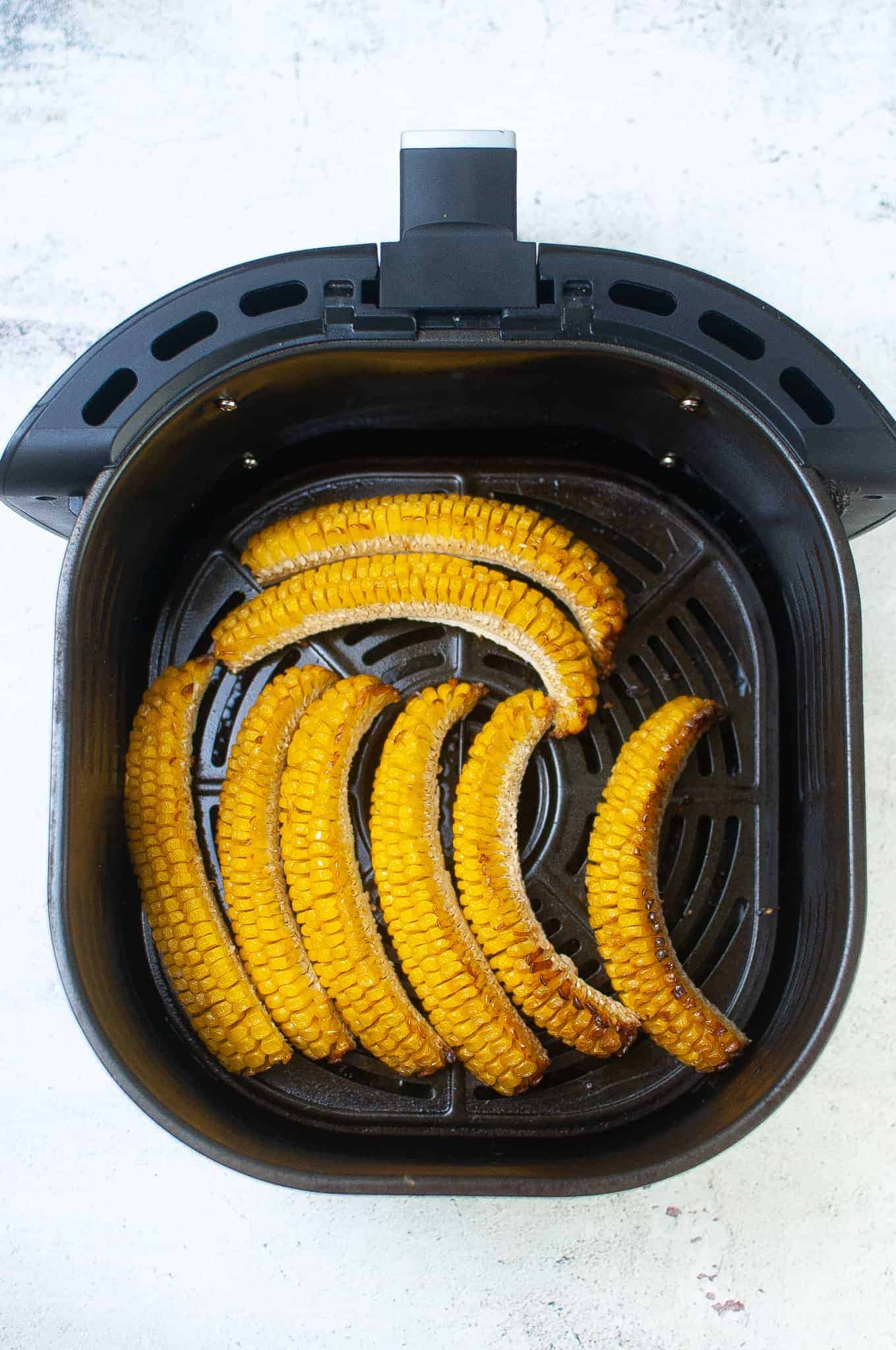 Corn ribs in air fryer basket.