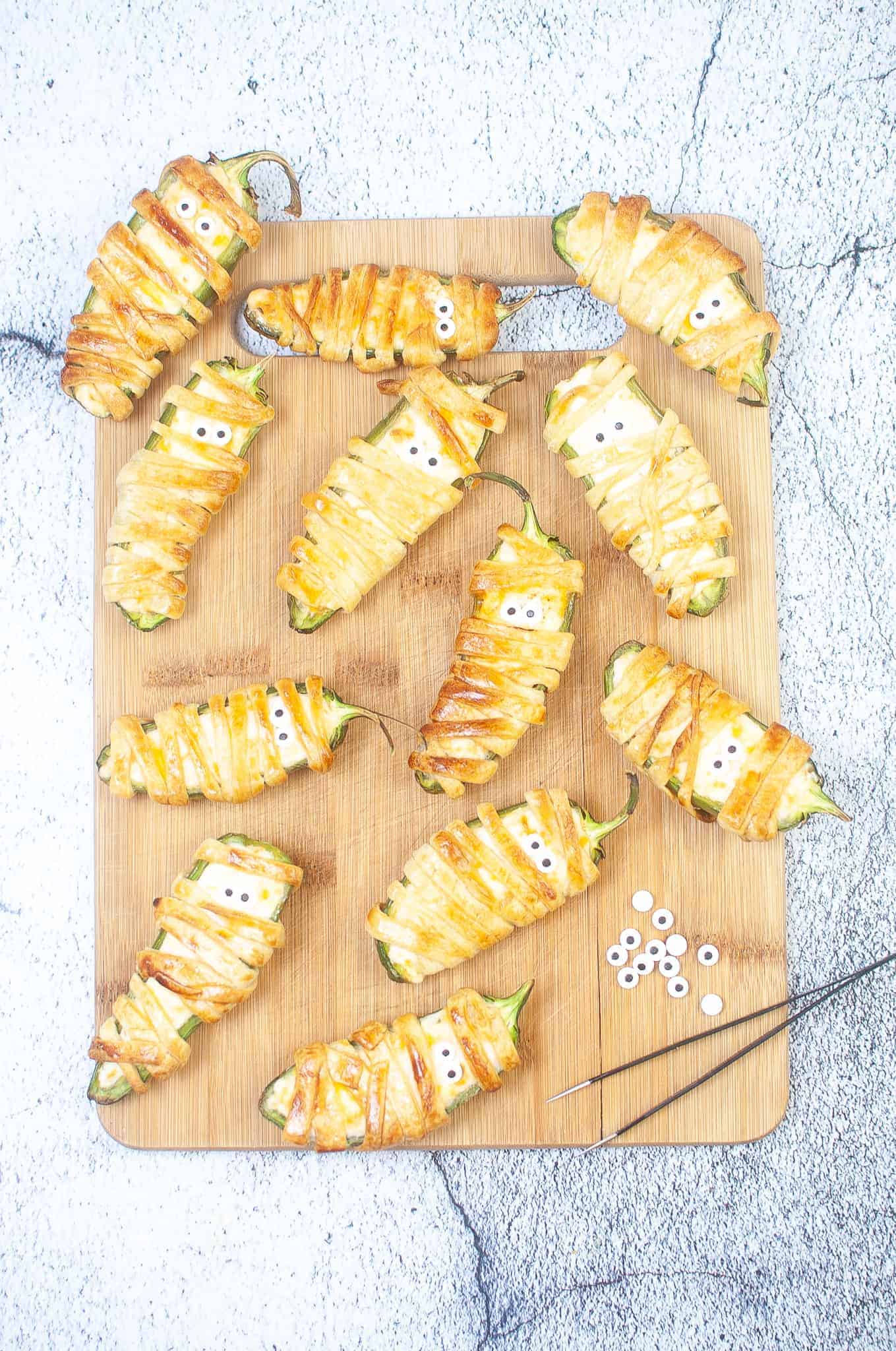 Overhead view of Air Fryer Mummy Jalape&ntilde;o Poppers on a cutting board.