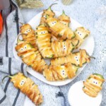Overhead view of Jalape&ntilde;o Mummy Poppers on a white plate.
