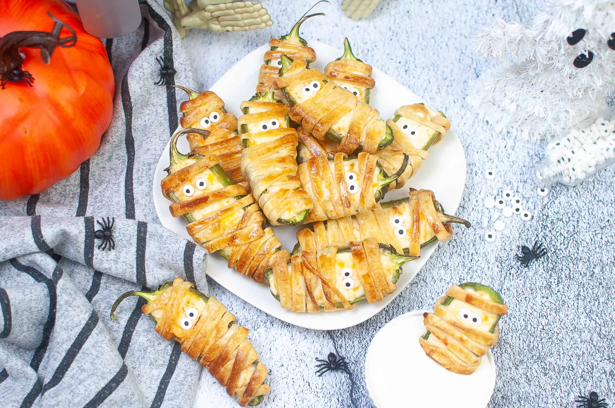 Overhead view of Jalapeño Mummy Poppers on a white plate.