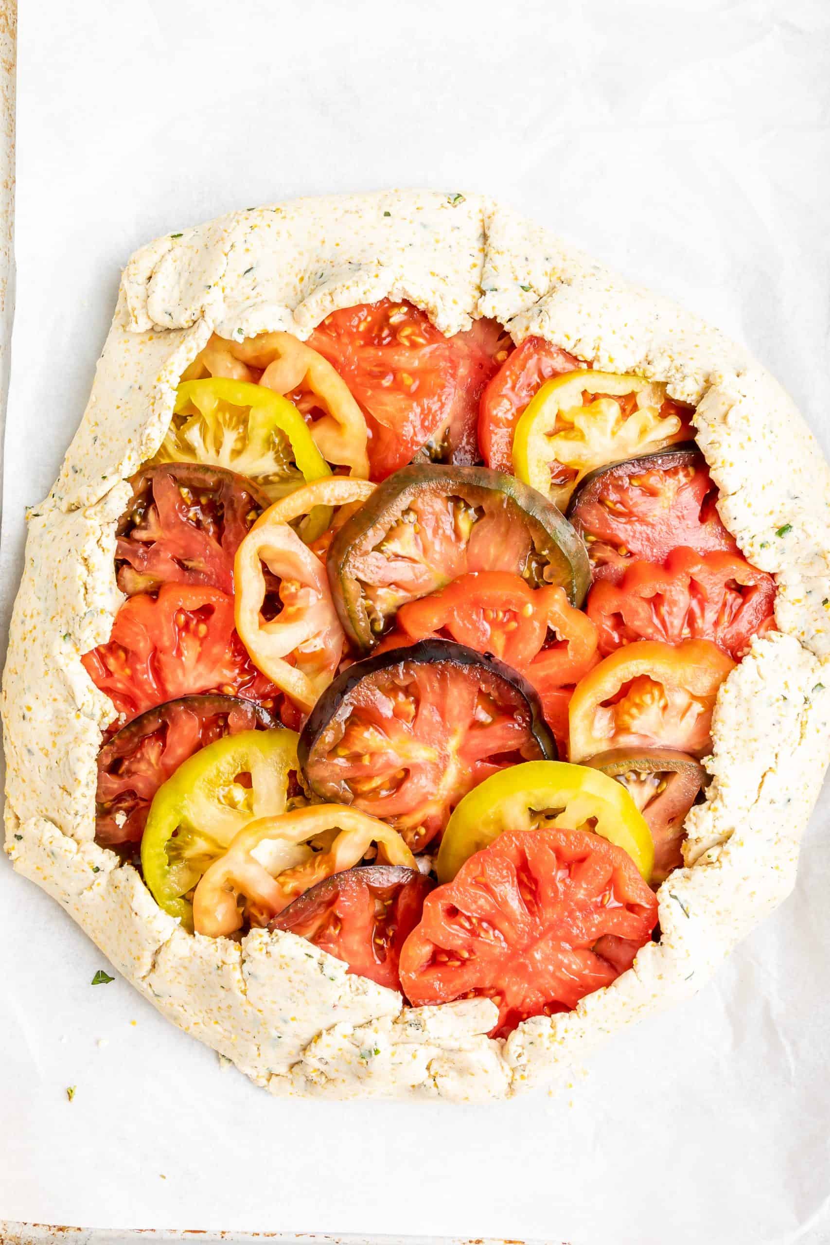 Overhead view of tomato galette in gluten-free crust before it is baked.