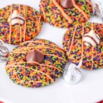 Halloween cookies with sprinkles and Hershey and Hugs Kisses on a plate.