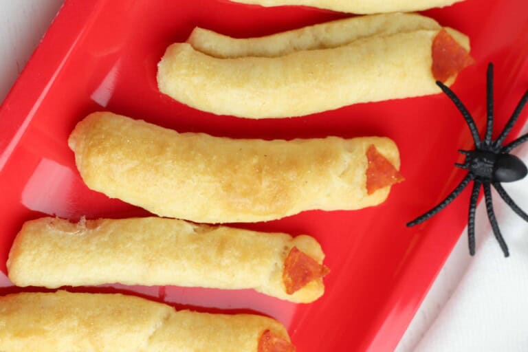 Breadsticks with pepperoni on a red plate.