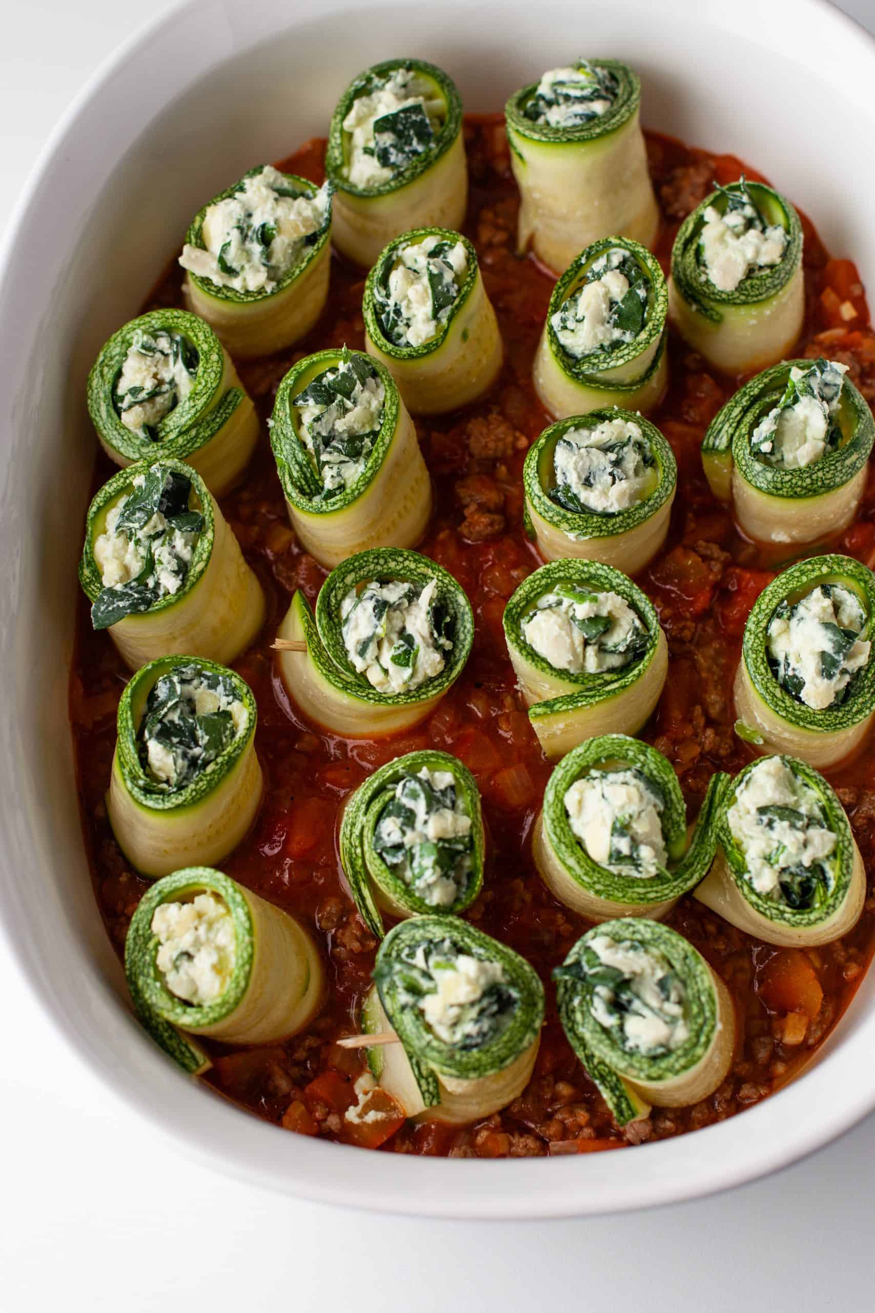 Zucchini Lasagna Rolls in a white casserole dish.