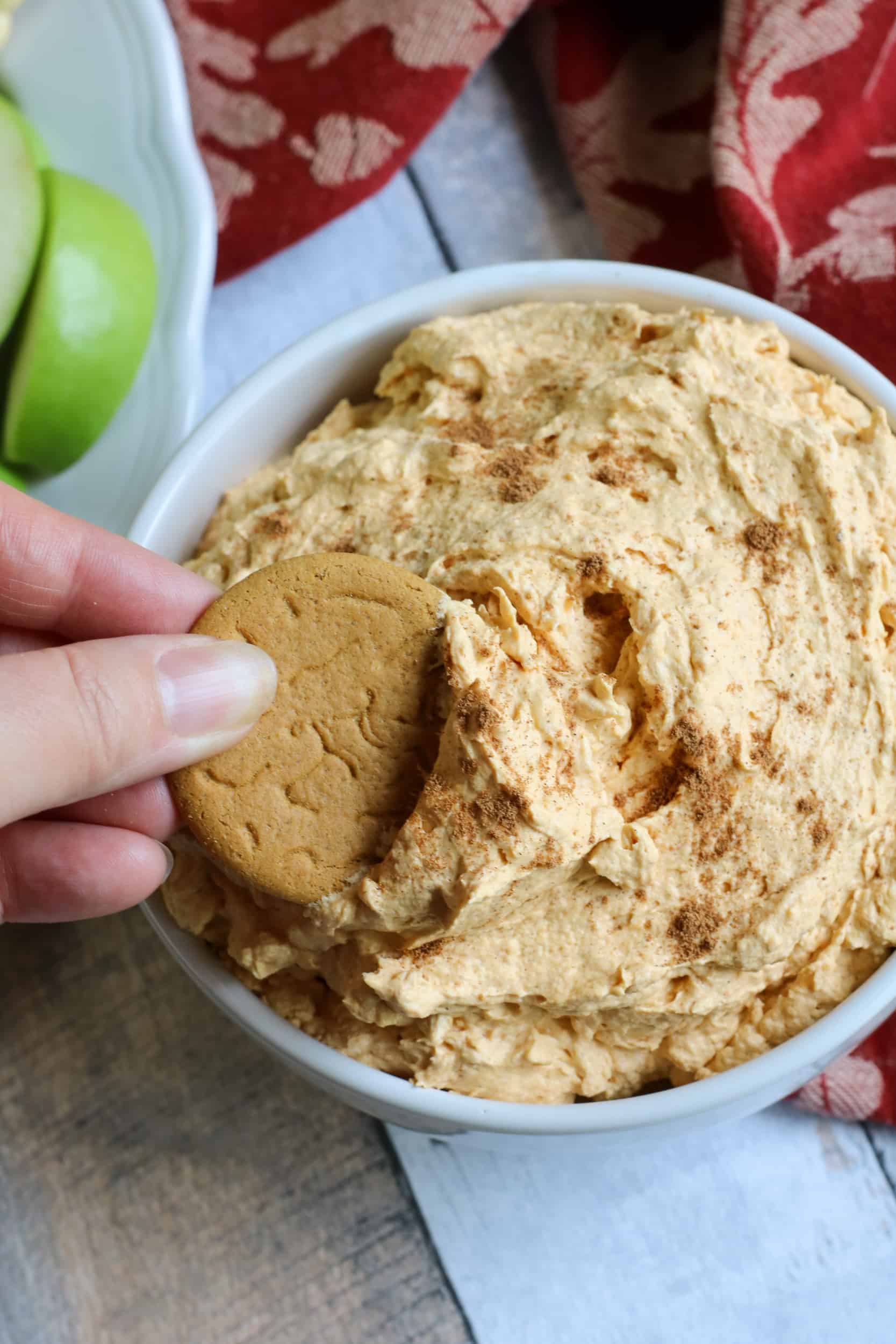 Gingerbread cookie in bowl of pumpkin fluff.