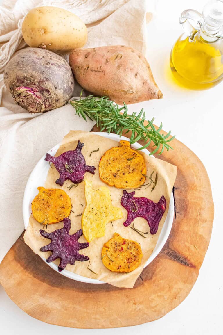 Overhead view of roasted Halloween vegetables on a white plate.
