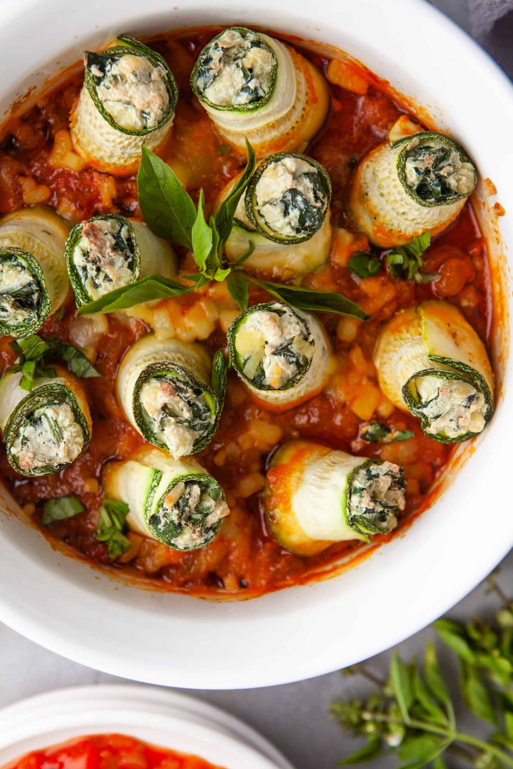 Overhead photo of Zucchini Lasagna Rolls in a white casserole dish.